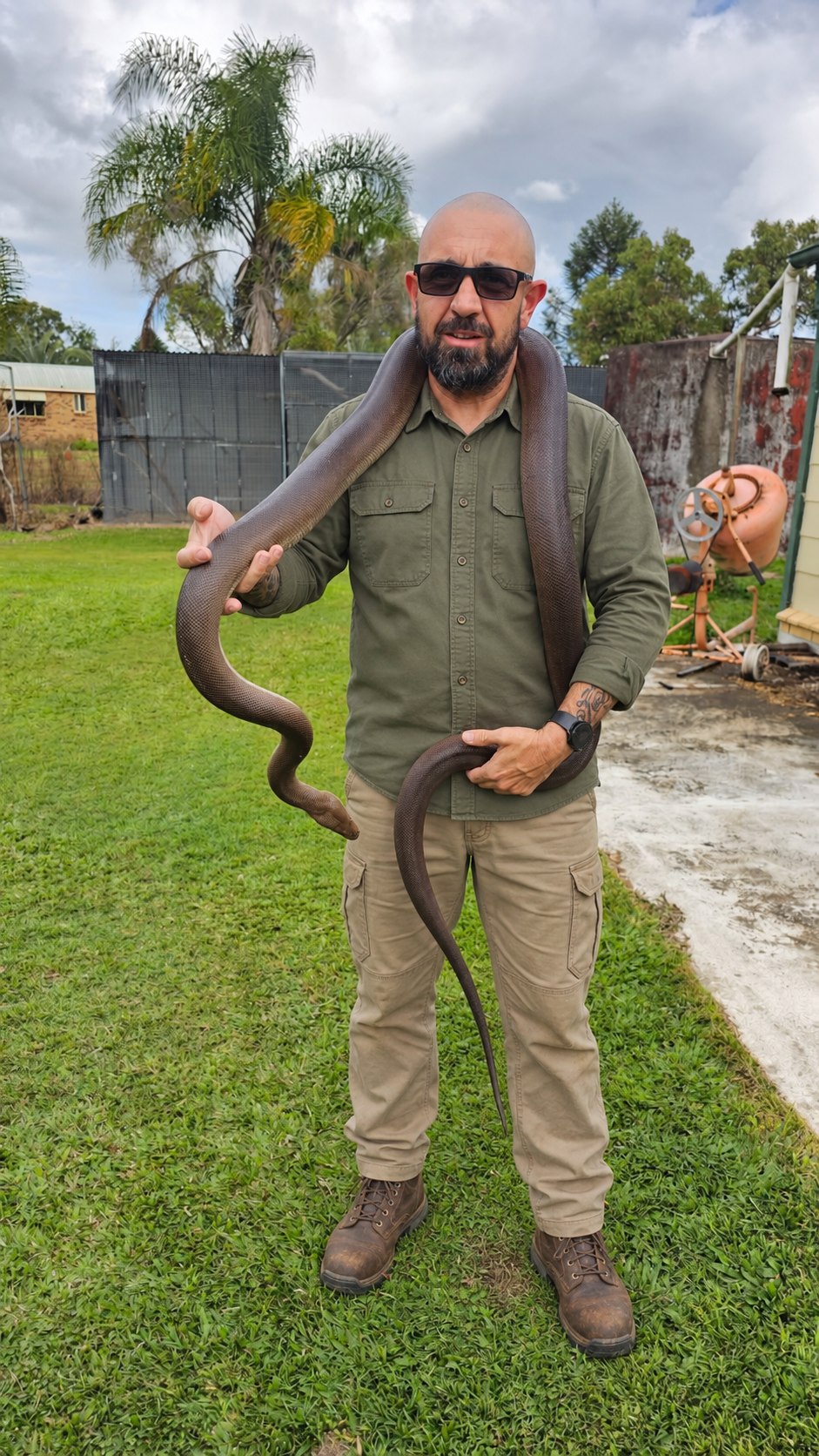 Russell holding a snake, with his field outfit digitally styled